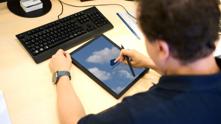 Mitarbeiter tippt am Tablet die asut.cloud an - IT-Lösungen